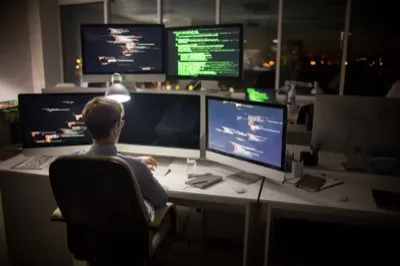 Developer at desk with multiple monitors